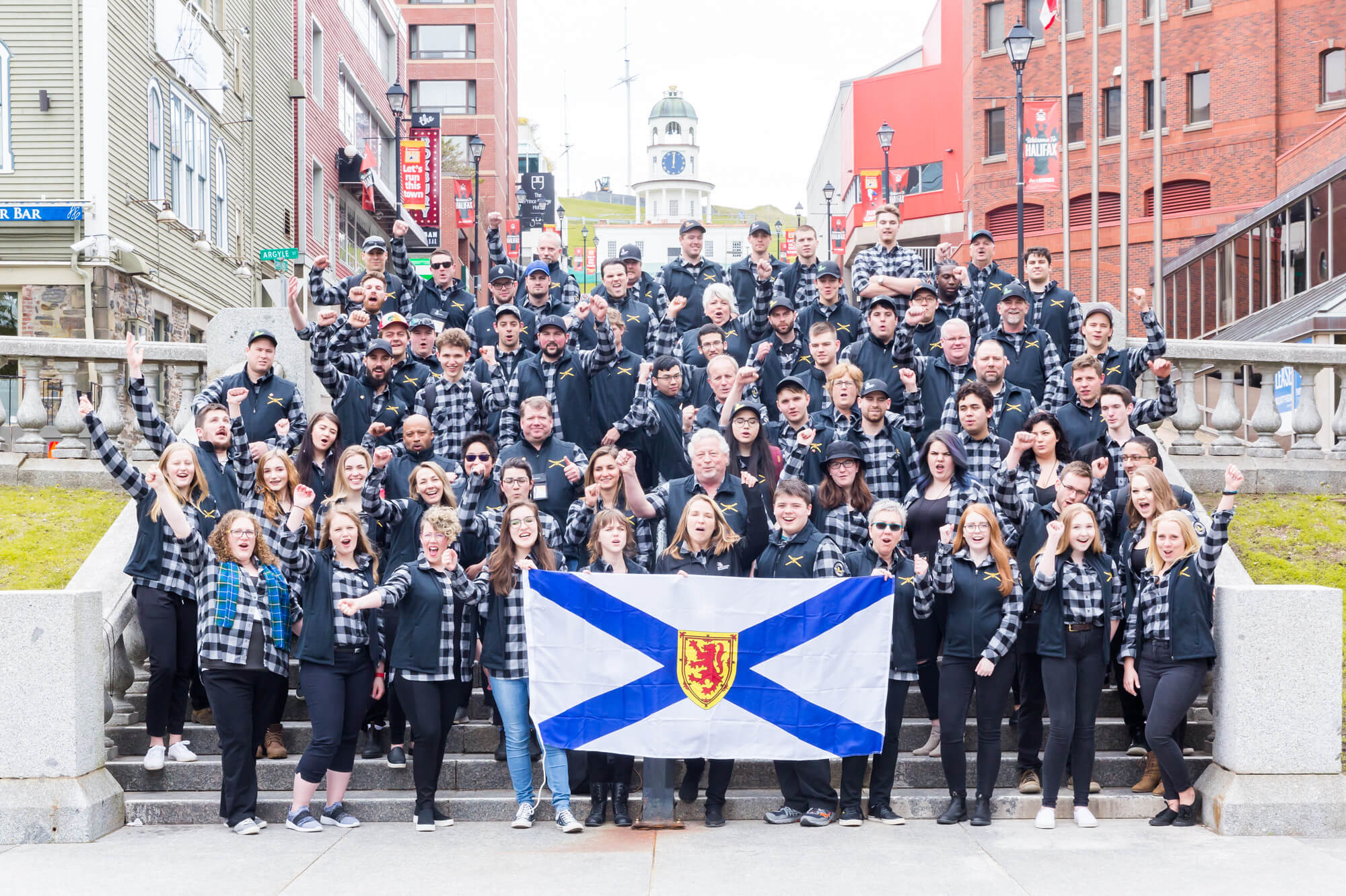 Group photo of the large team holding a Nova Scotia Flag